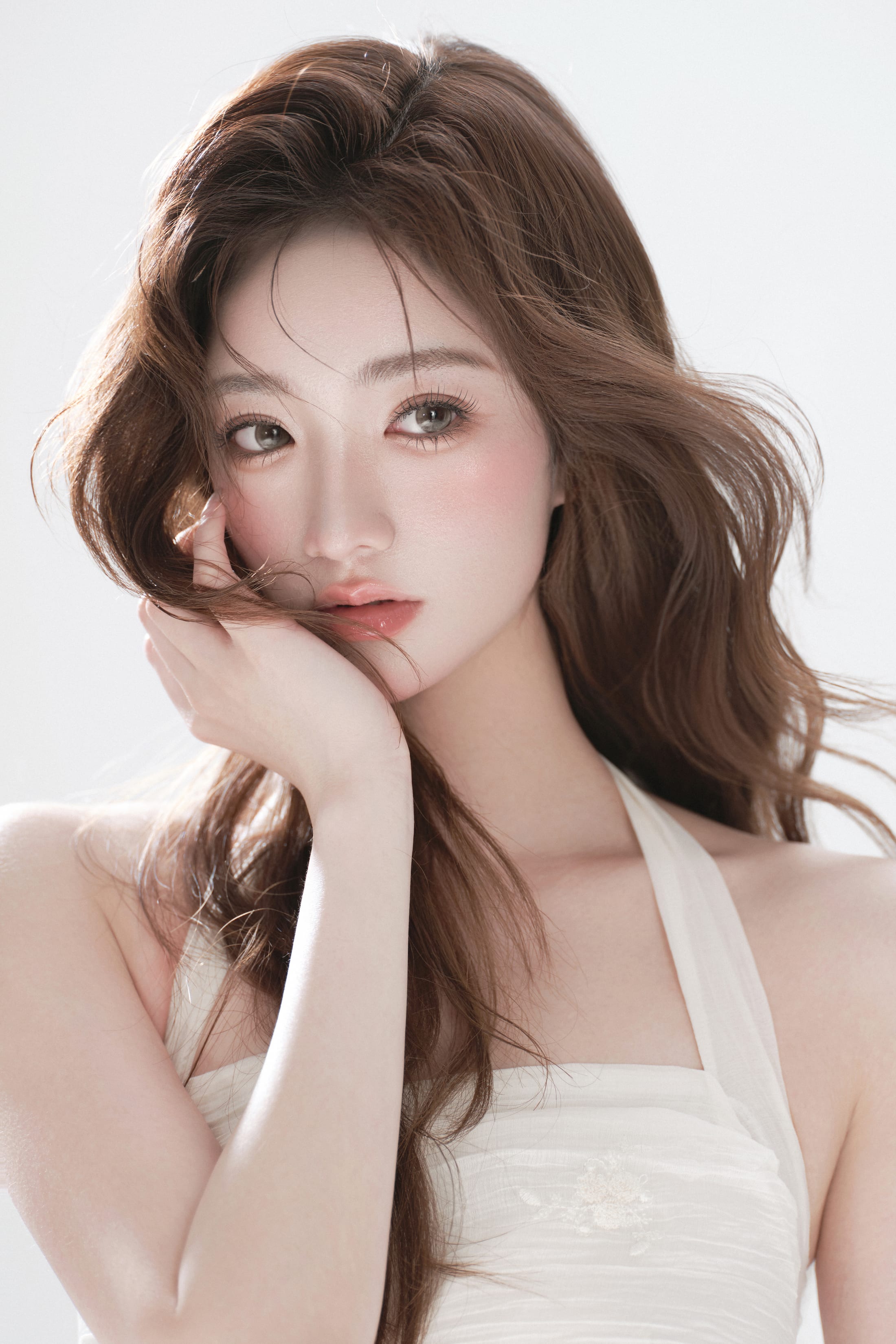 K9 Studio soft glam portrait, hand resting on the cheek, loose waves, cream halter top